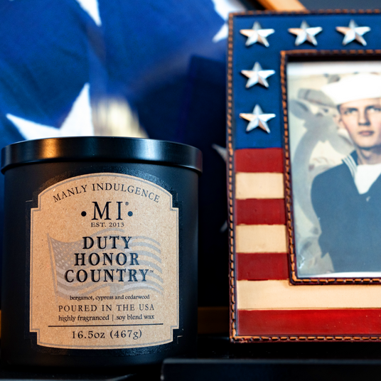 an image of the candle Classic Plus Duty Honor Country placed next to the image of a soldier with a flag in the background